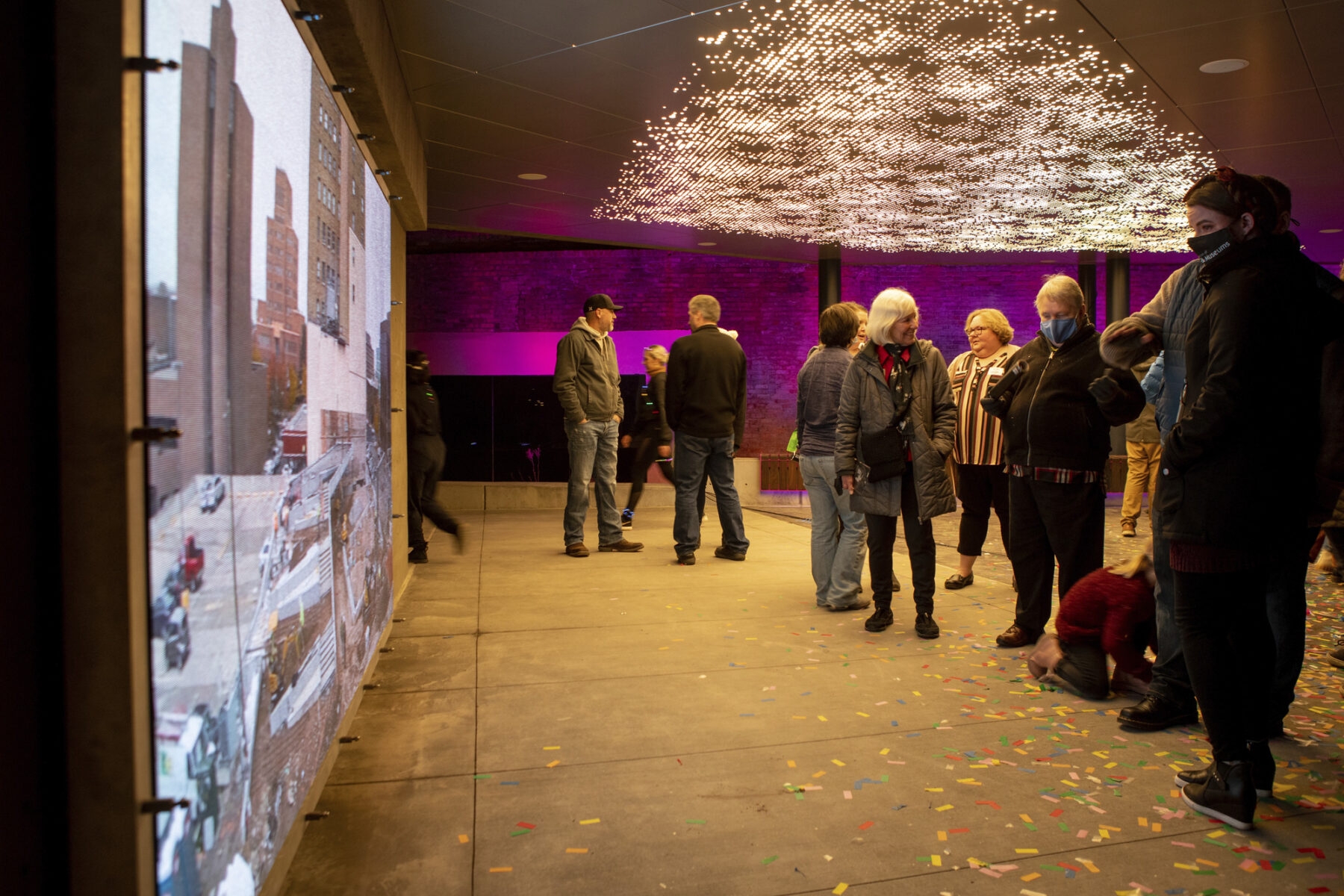 photograph of people enjoying art projections on wall and ceiling of venue space