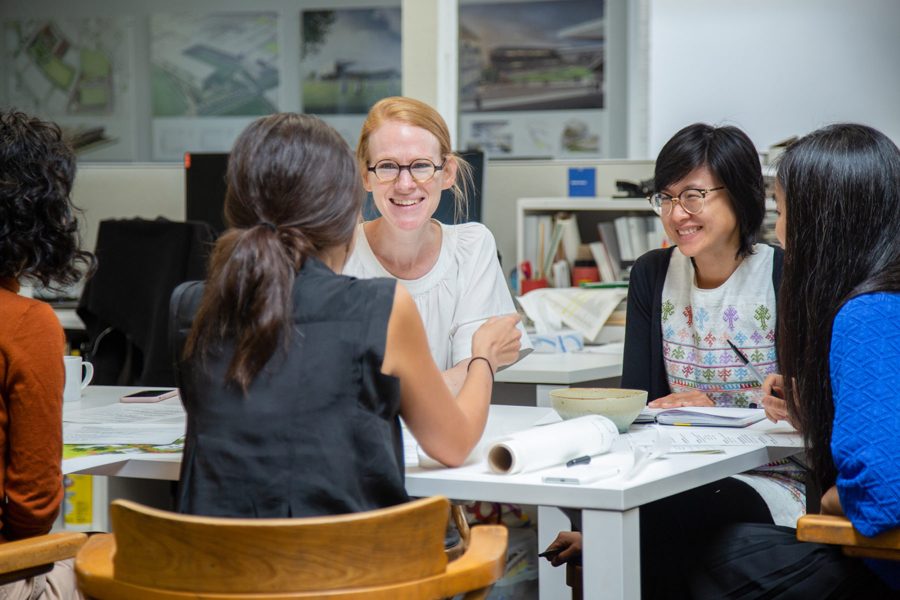 Women sitting around a table discussing a design drawing