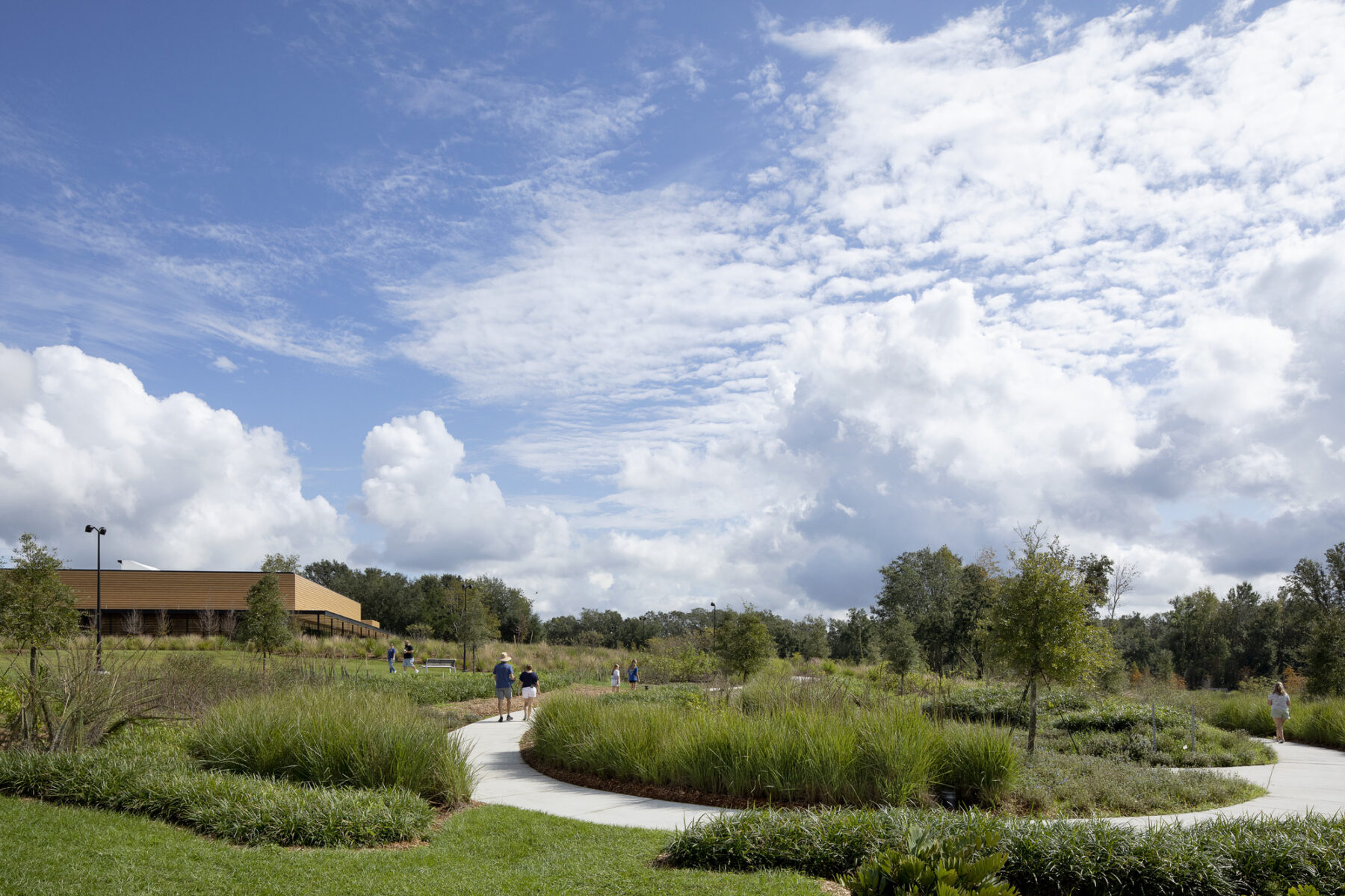 View into botanical garden with walking path leading towards the event center building in the distance