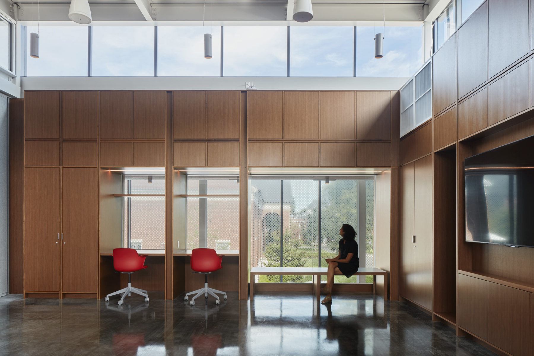 Interior photo of woman sitting alone in flex room looking out the window