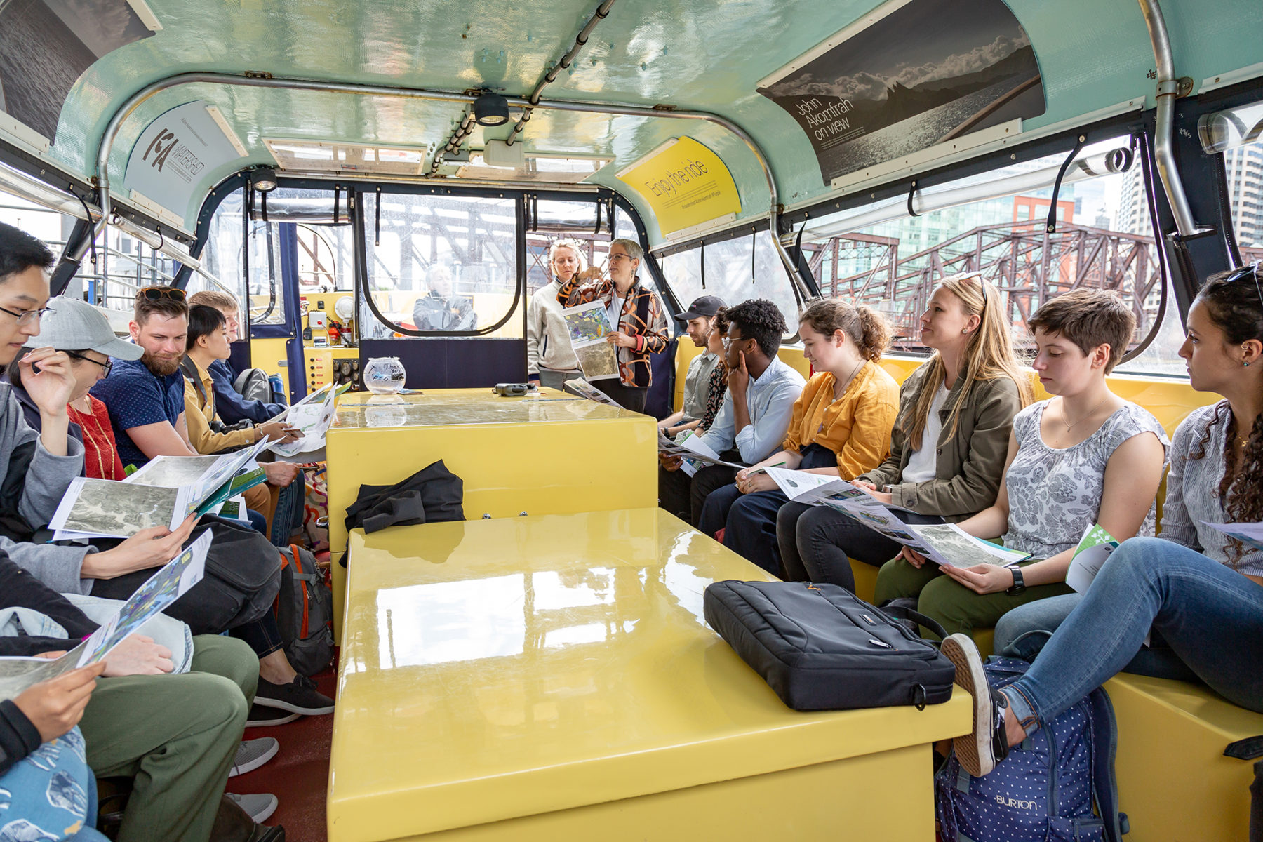 Group of people on a board listening to a presenter and looking at maps